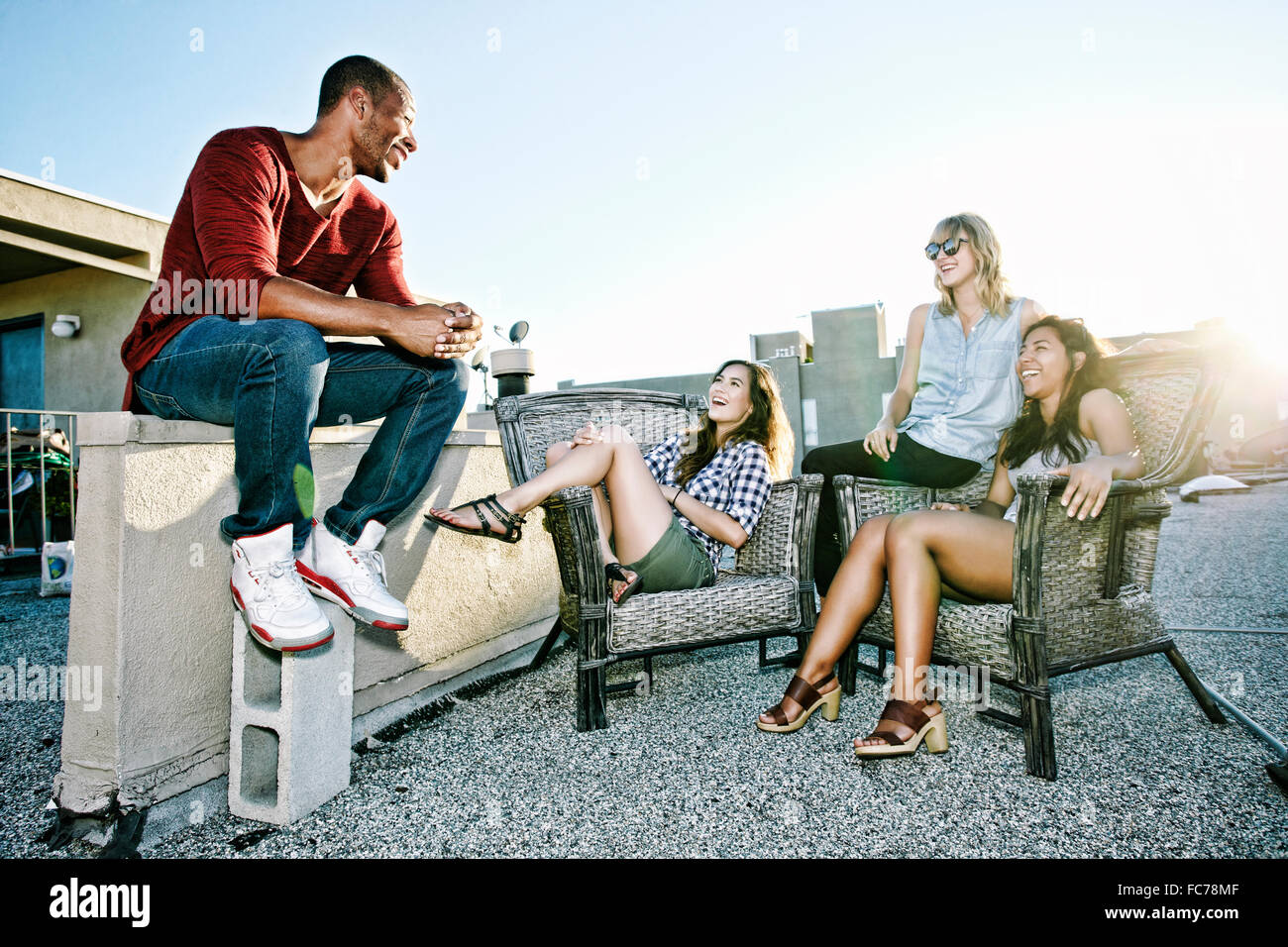 Amici in relax sulla terrazza sul tetto urbano Foto Stock