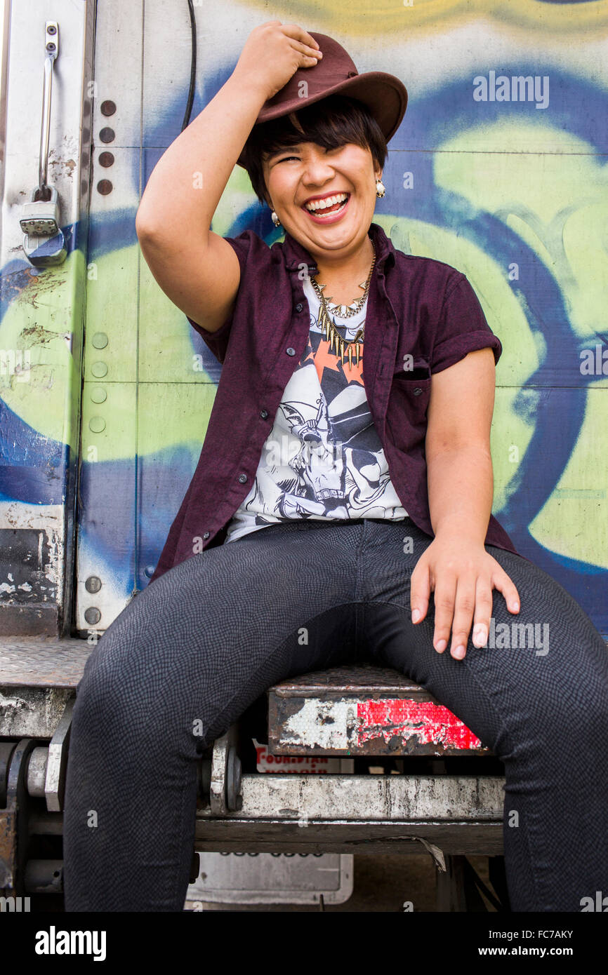 Donna asiatica seduta sul carrello graffiti Foto Stock