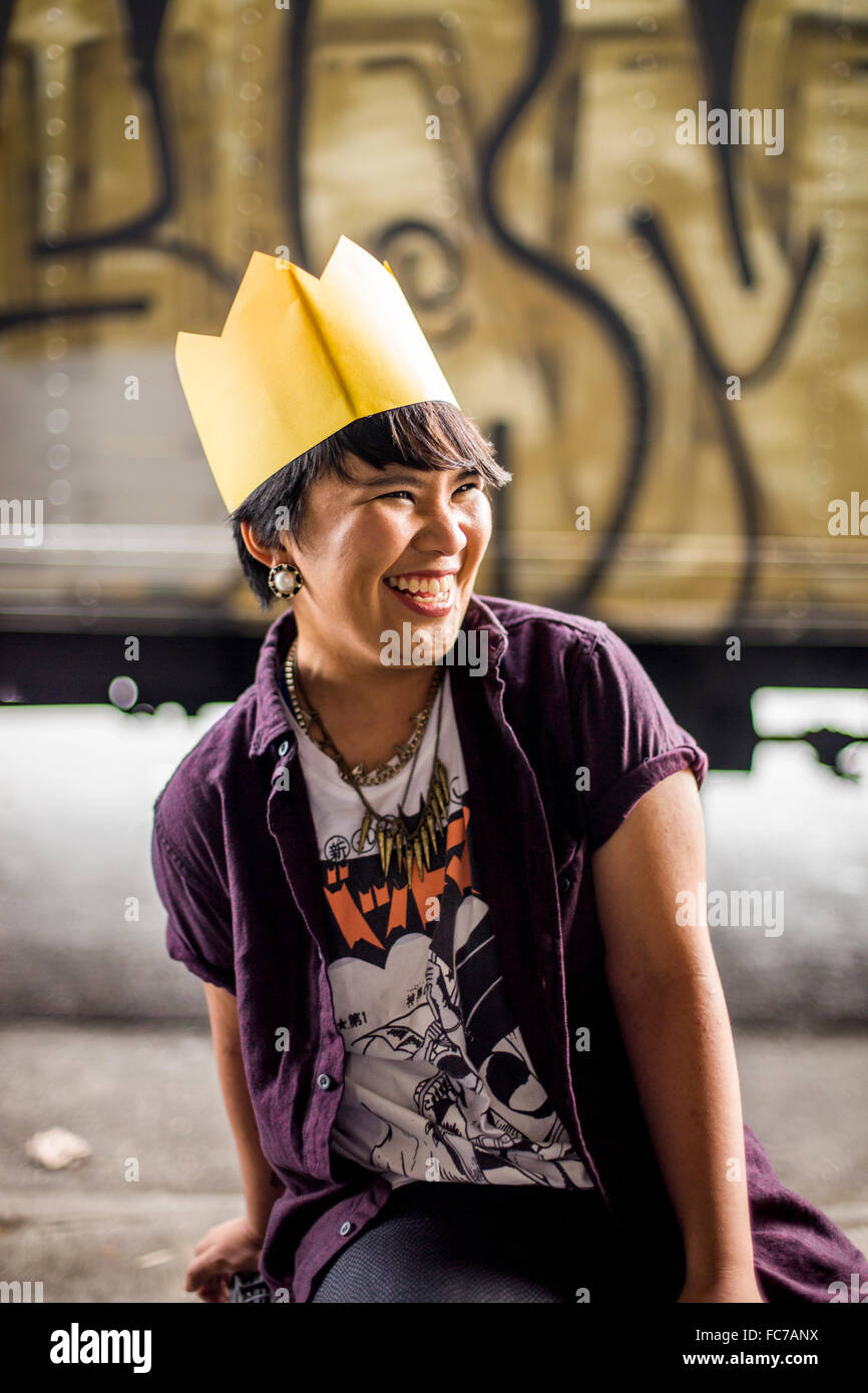 Donna asiatica che indossa la corona di carta Foto Stock