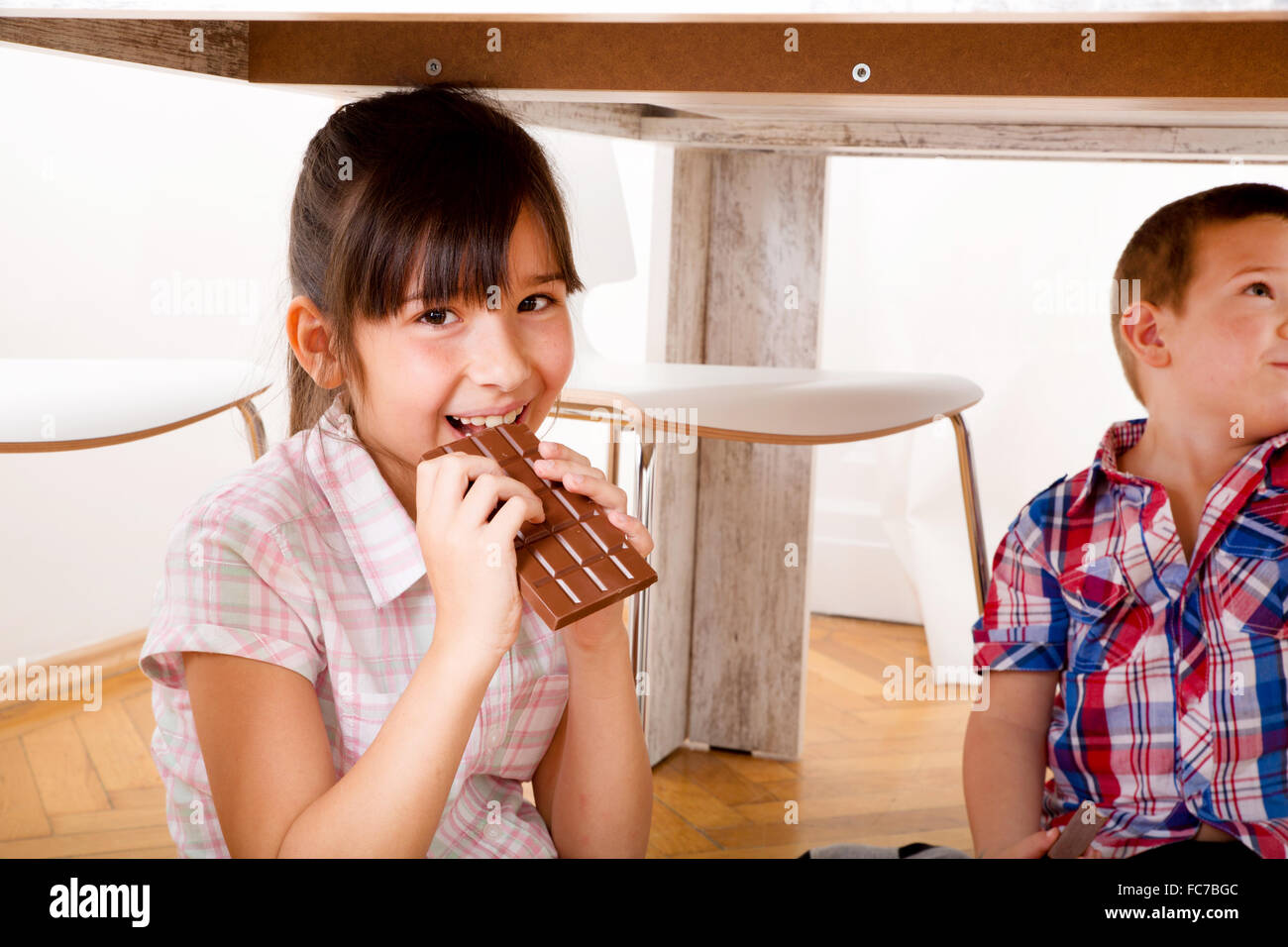 Bambini mangiare il cioccolato a casa Foto Stock