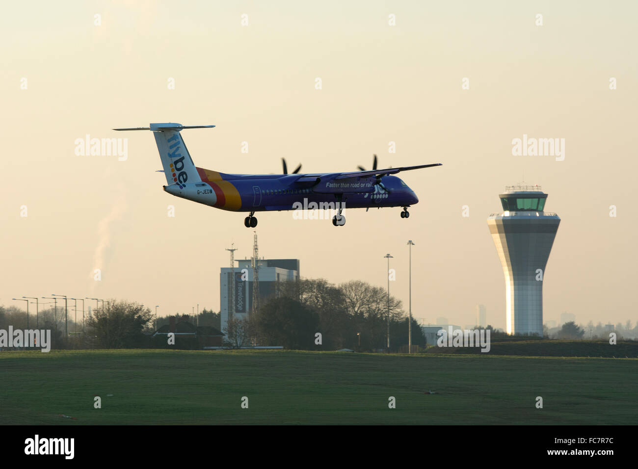 Flybe Dash 8 aerei di atterraggio all'Aeroporto di Birmingham all'imbrunire, REGNO UNITO Foto Stock