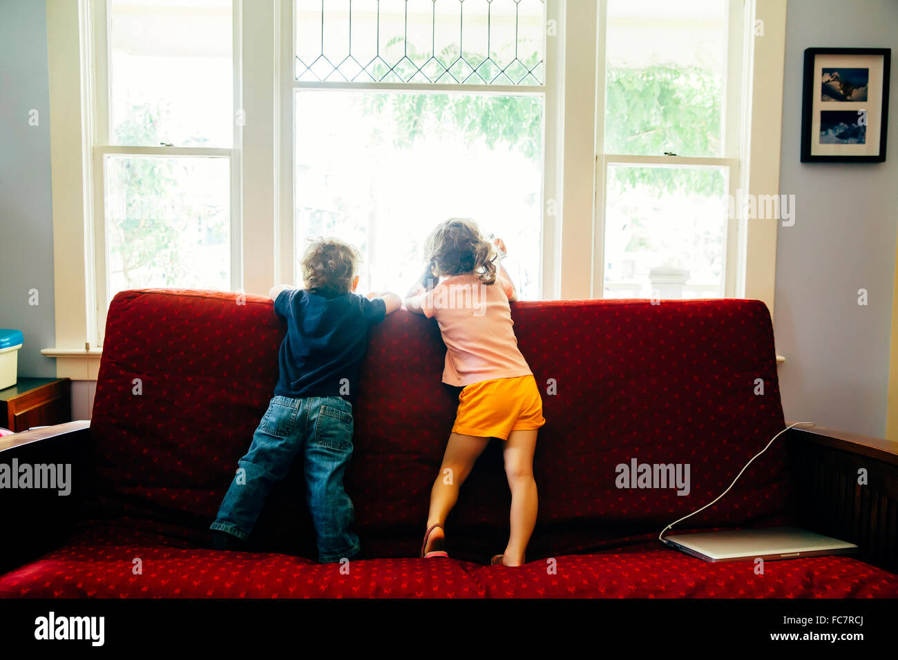 Bambini caucasici in piedi sul divano Foto Stock