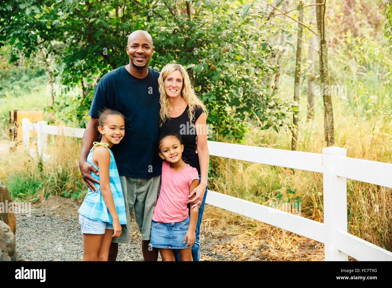 Famiglia sorridente sul sentiero di ghiaia Foto Stock