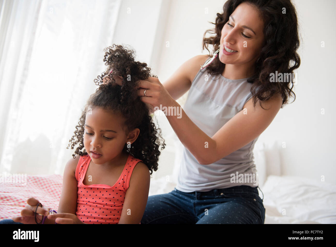 Madre per lo styling dei capelli della figlia Foto Stock