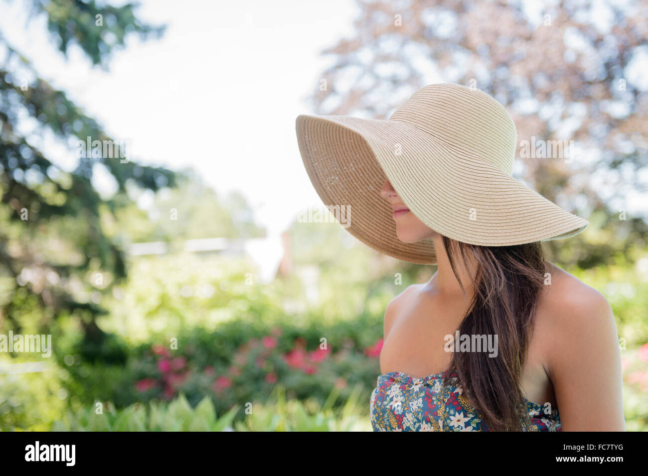 La donna caucasica indossando cappello per il sole all'aperto Foto Stock