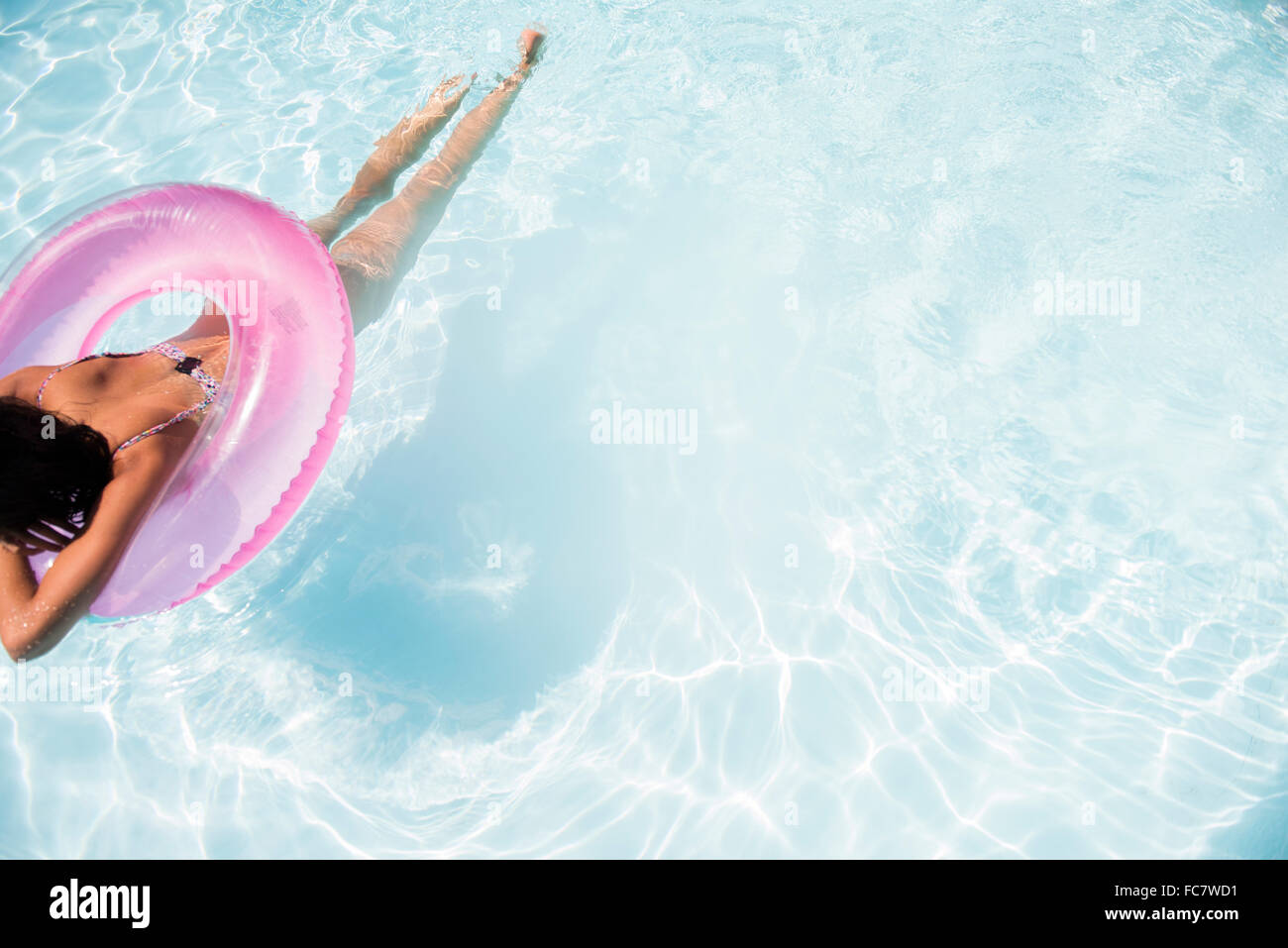 La donna caucasica galleggianti in piscina Foto Stock