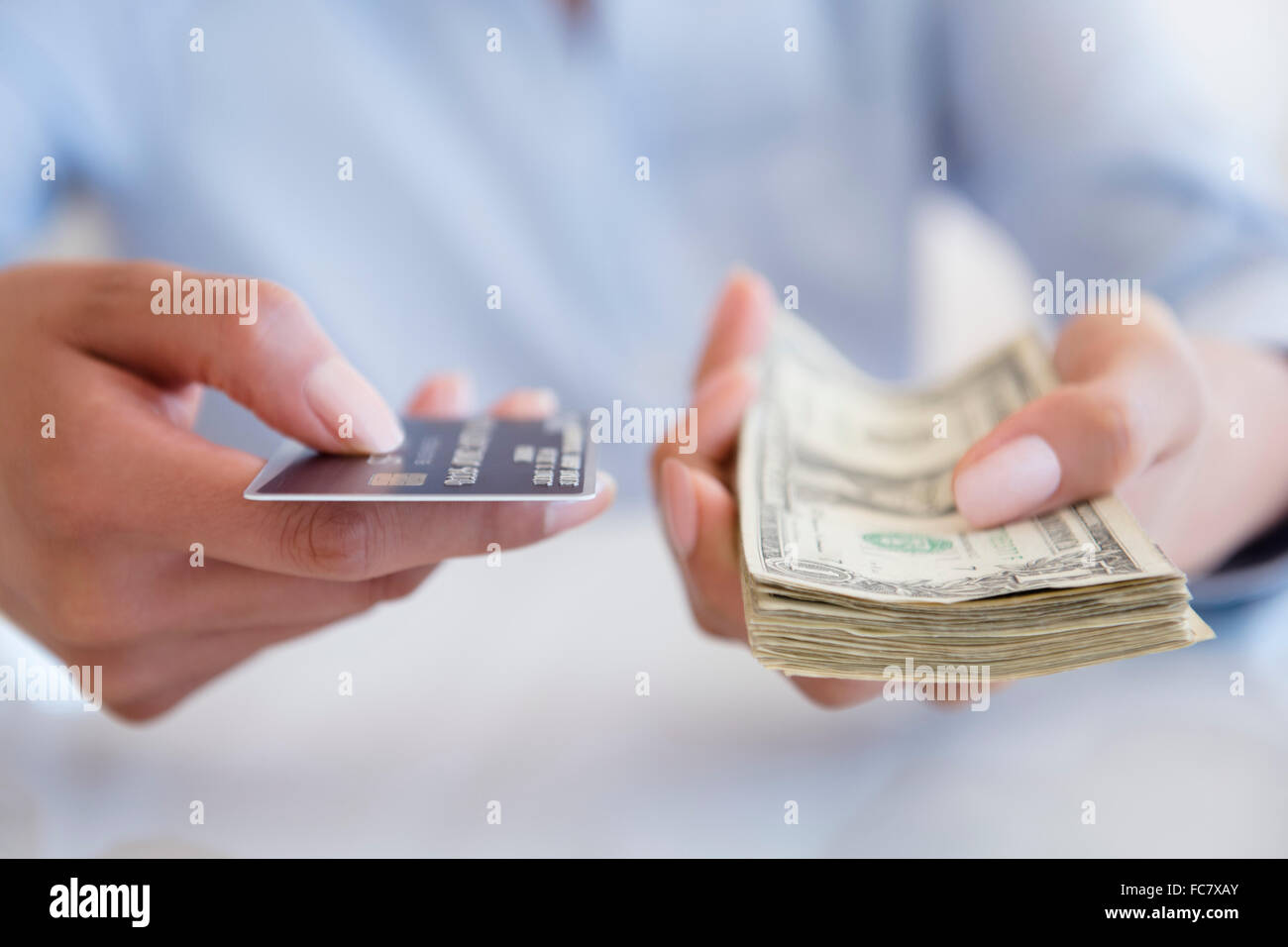 Donna ispanica tenendo in contanti e con carta di credito Foto Stock