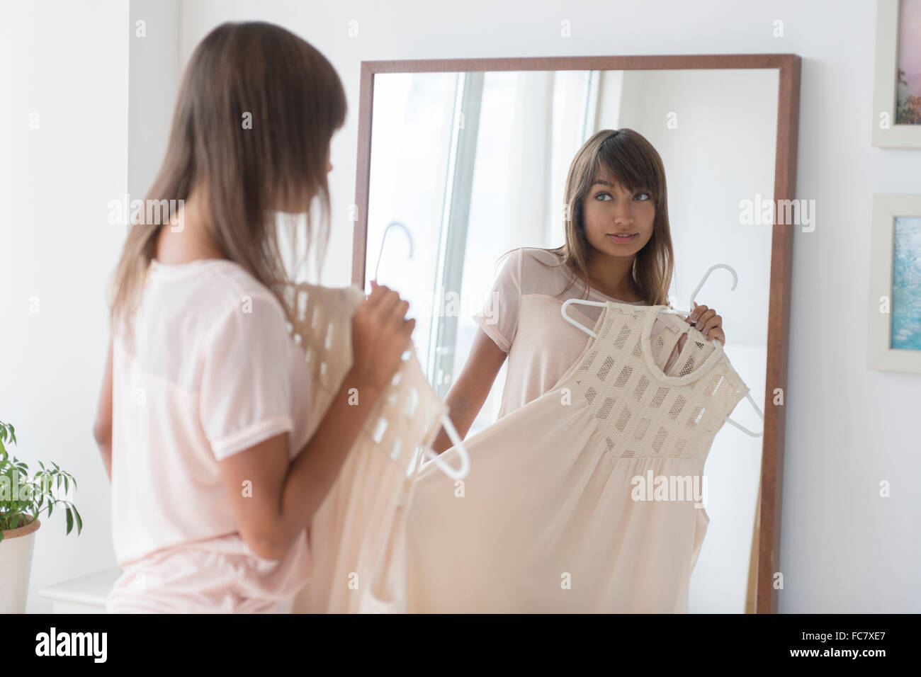 Razza mista donna esame vestito in specchio Foto Stock
