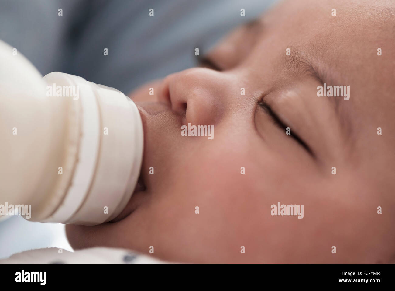 Close up di razza mista boy allattamento al biberon Foto Stock