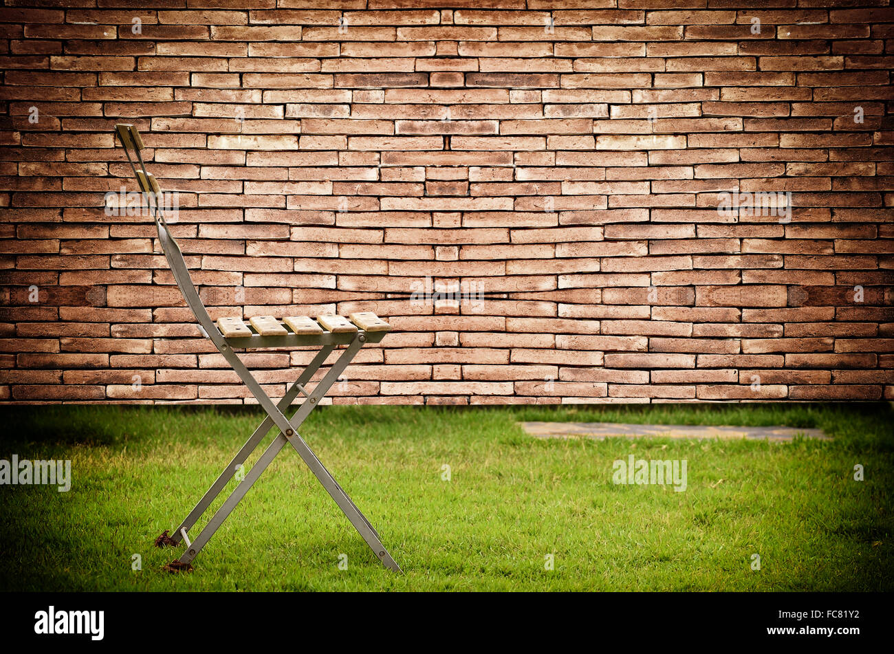 Vecchia sedia sul vecchio muro Sfondo mattone Foto Stock