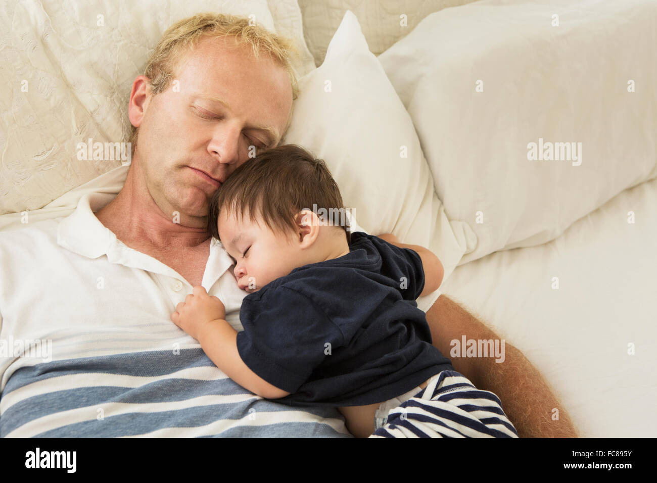 Padre e Figlio bambino che dorme sul letto Foto Stock