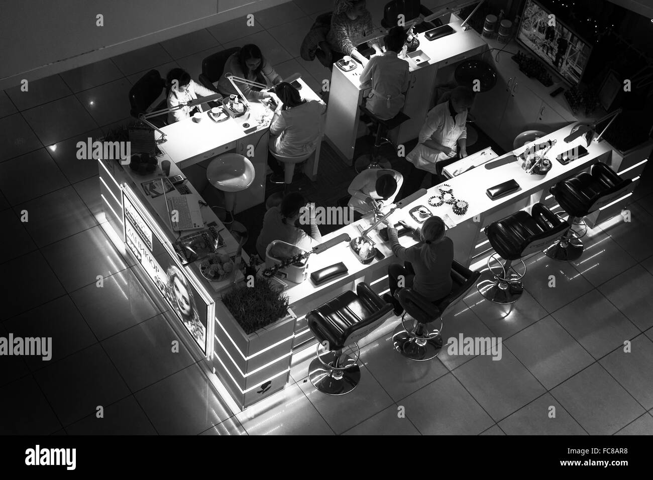 Moderno nail bar prelevato da un alto punto di vantaggio che guarda le donne aventi le loro unghie eseguita in bianco e nero Foto Stock