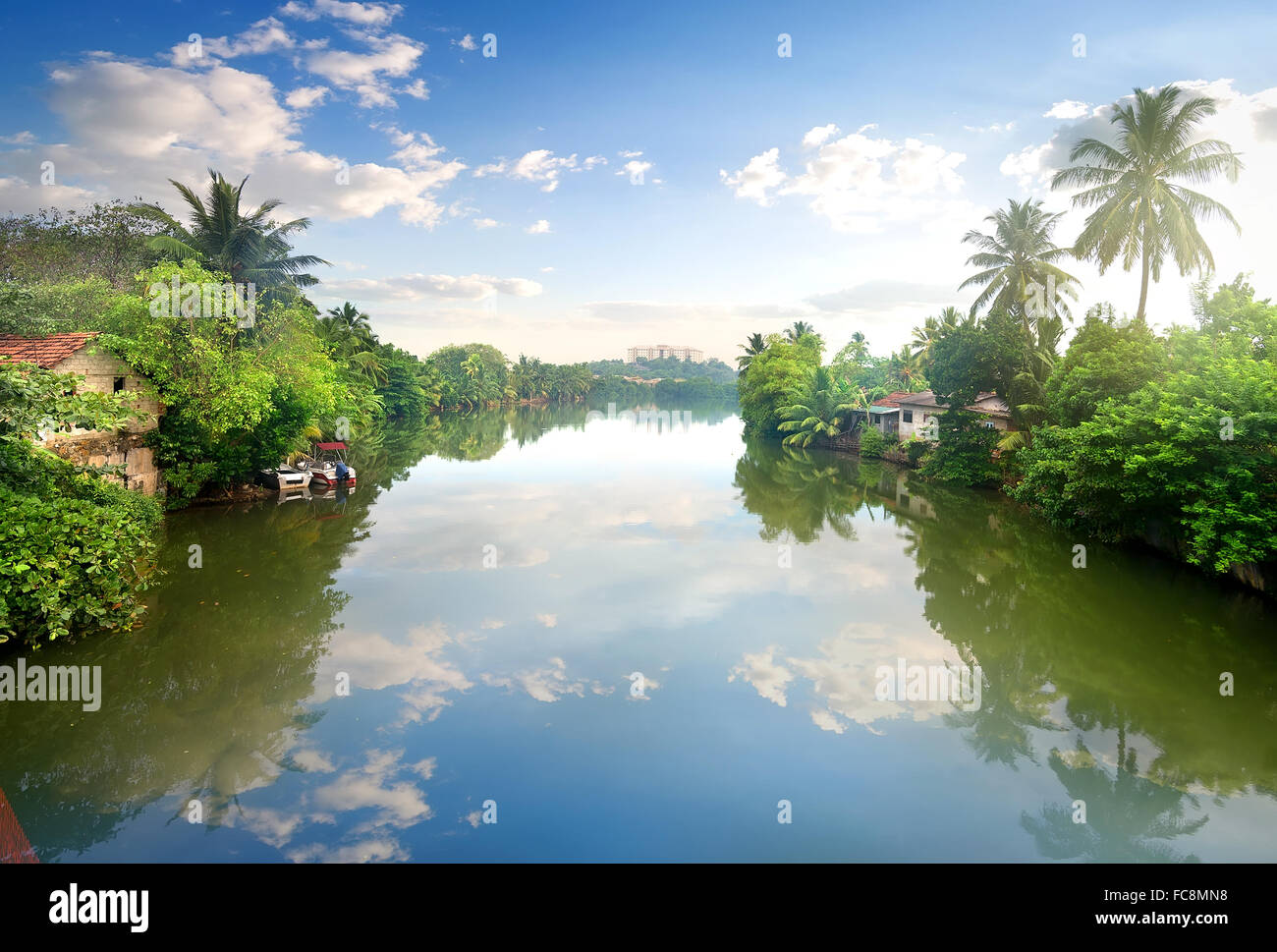 Piccole case sulle rive di un fiume in junles dello Sri Lanka Foto Stock