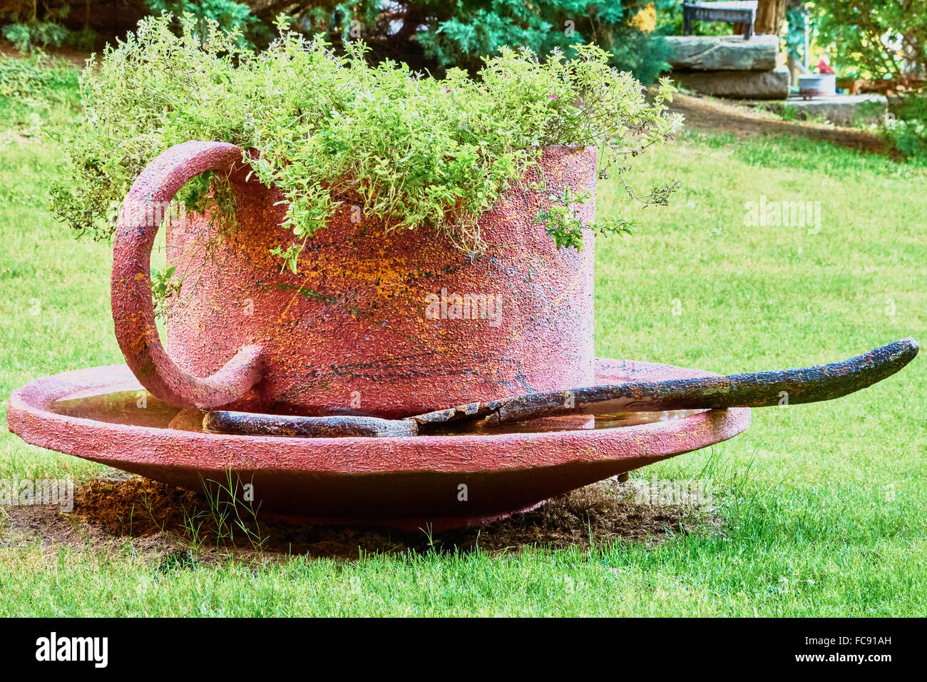 Giardino scultura tazza e piattino su un green glade Foto Stock