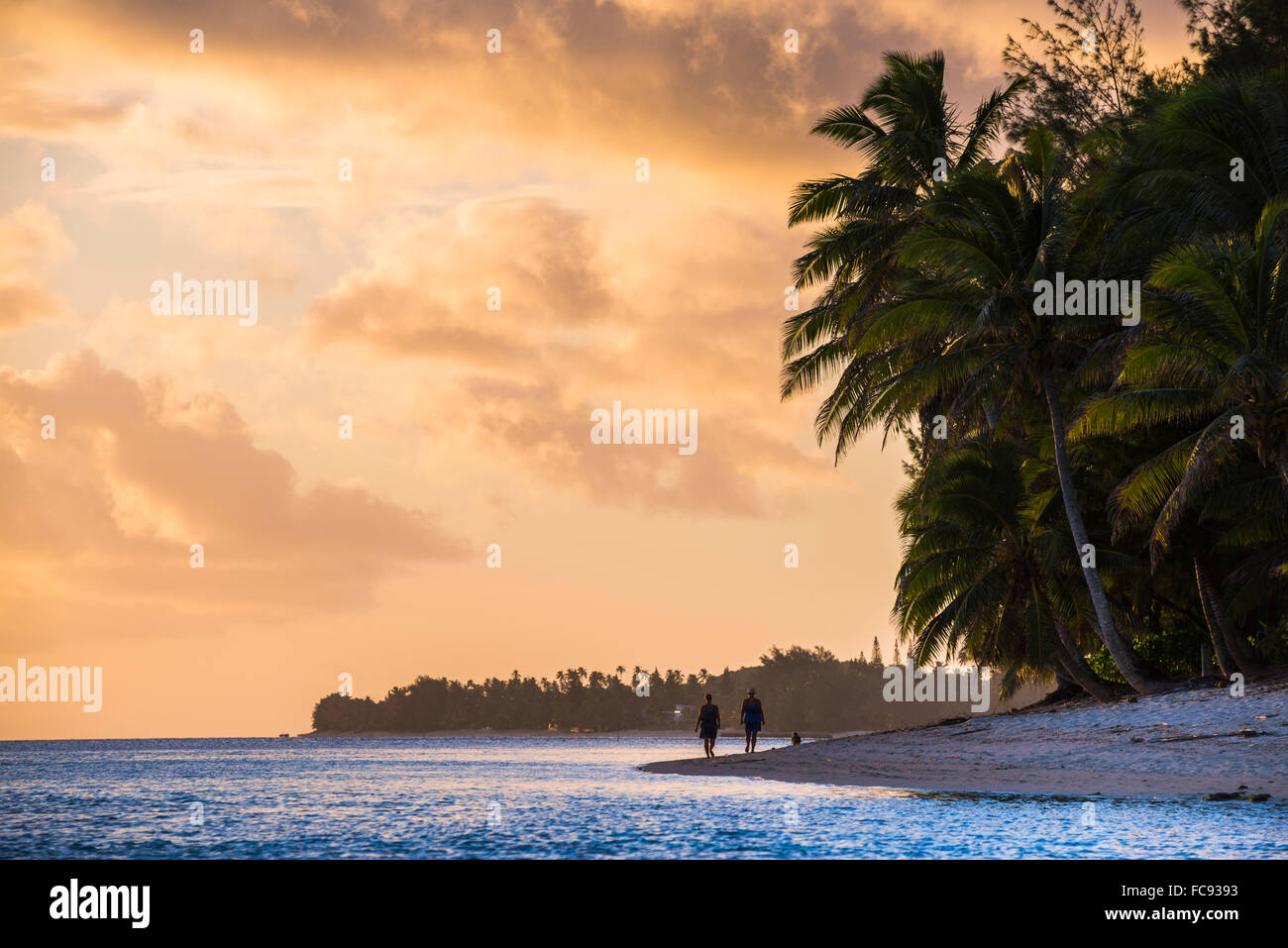 Camminando lungo una spiaggia tropicale al tramonto, Rarotonga Isole Cook, South Pacific Pacific Foto Stock