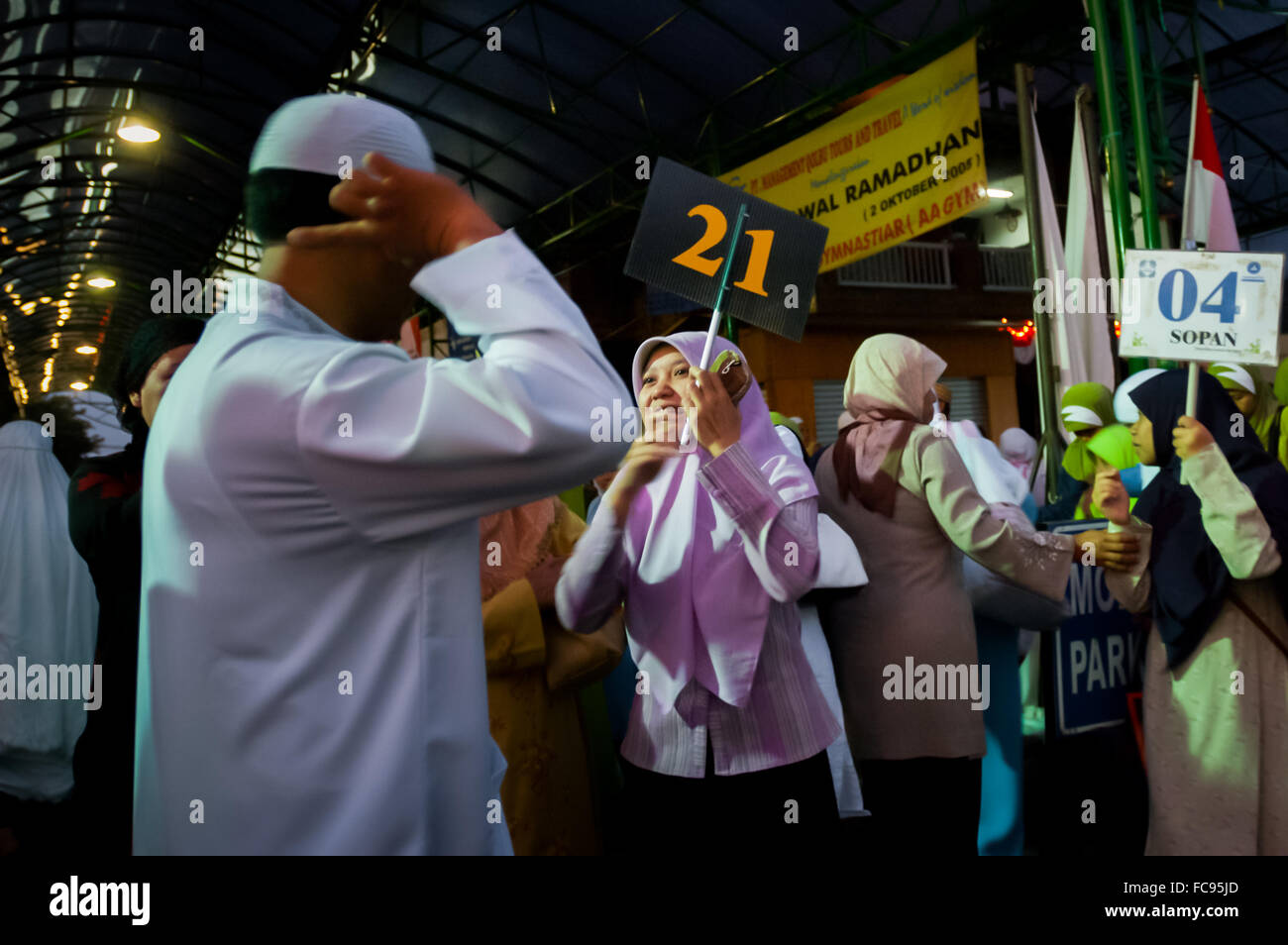 Guida/facilitatore che chiama i partecipanti del tour religioso islamico per un briefing, durante un tour religioso a Gegerkalong, Bandung, Giava Occidentale, Indonesia. Foto Stock