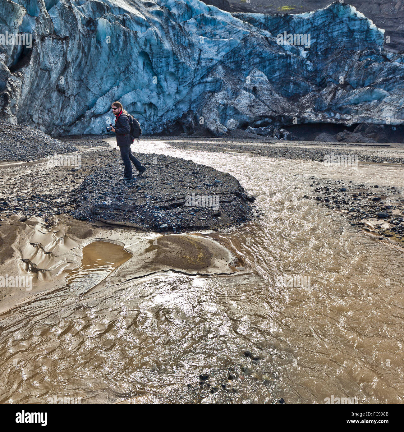 Uomo in piedi sulle sabbie da Gigjokull- uscita dal ghiacciaio Eyjafjallajokull tappo di ghiaccio. Foto Stock