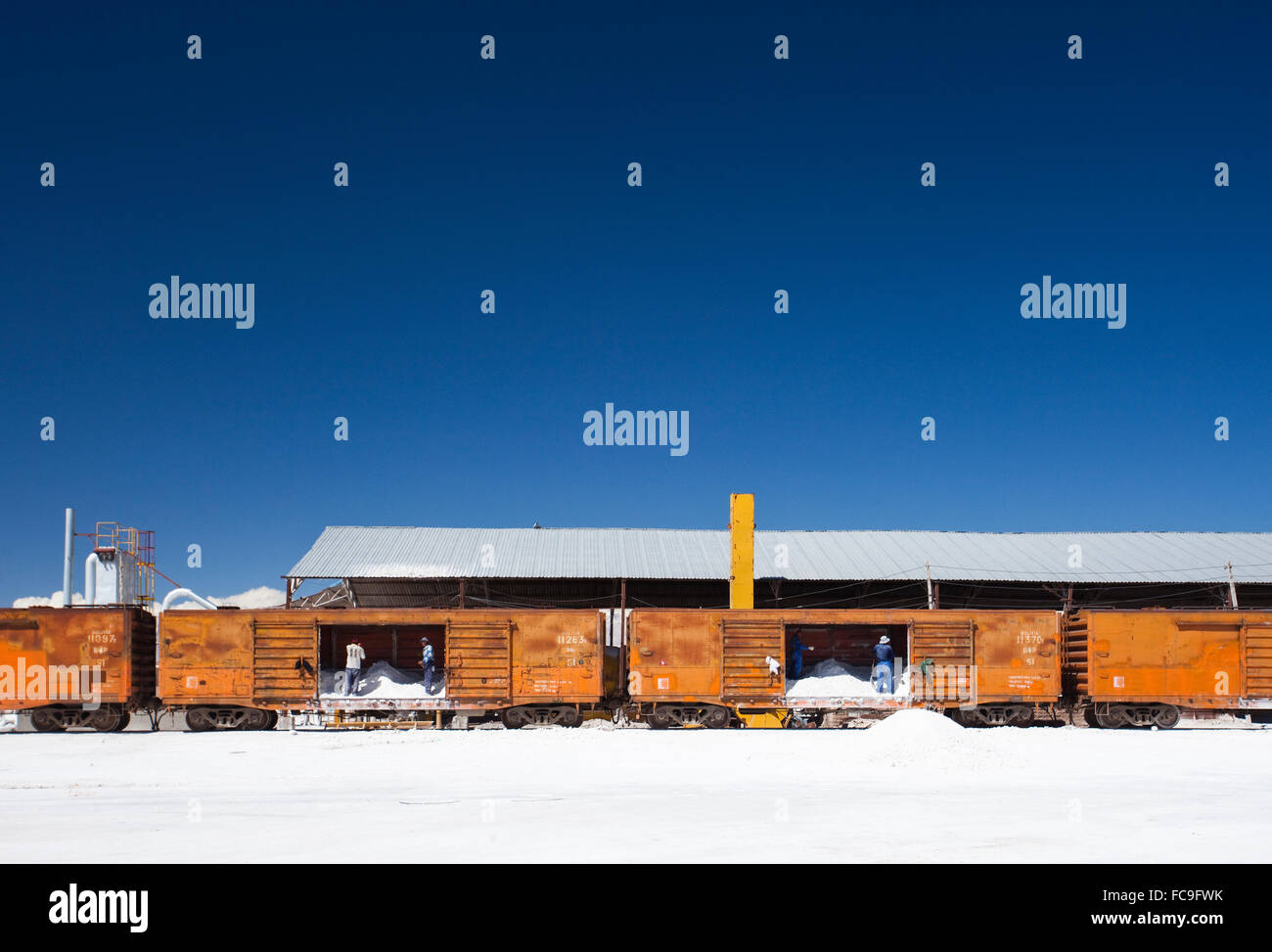 I lavoratori caricano sale nei treni nel Salar de Uyuni, in Bolivia, la più grande distesa di sale del mondo. Ospita anche il più grande Foto Stock