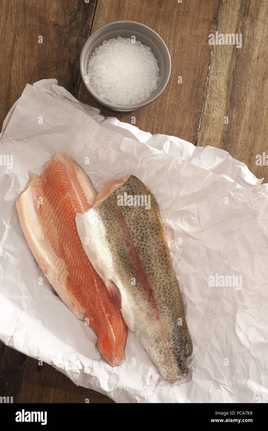 La trota iridea la carne su un tavolo con il sale Foto Stock