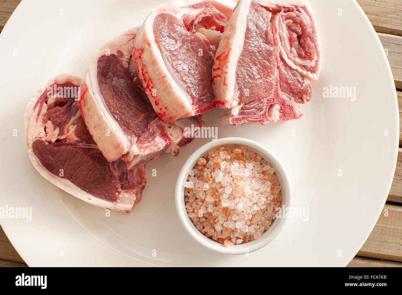 Carni di agnello costolette di carne sulla piastra con sale Foto Stock
