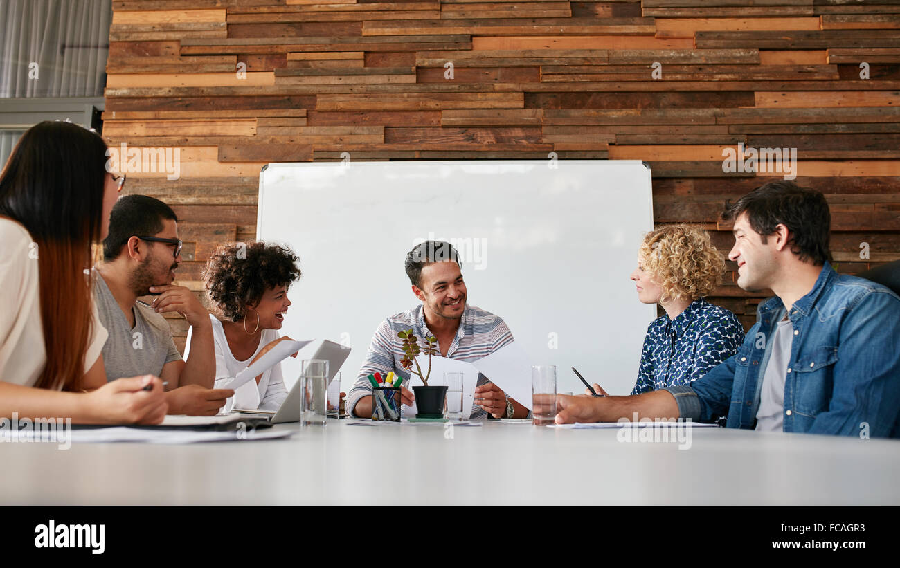 Un gruppo di giovani felice la gente di affari riuniti nella sala conferenze. Team di professionisti creativi per discutere il nuovo progetto. Foto Stock