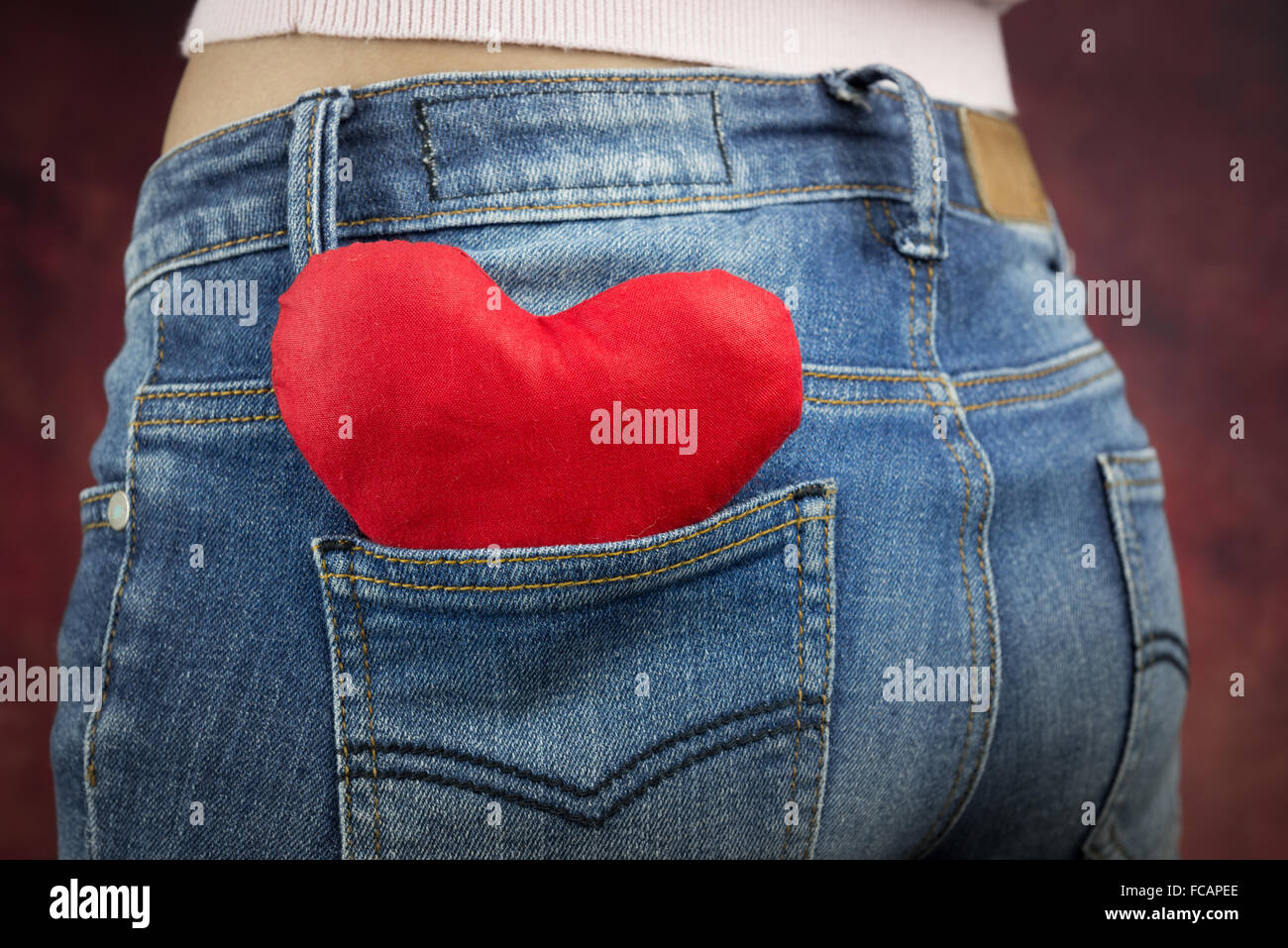 Cuore rosso nella tasca posteriore dei jeans di donna, Valentino del concetto Foto Stock