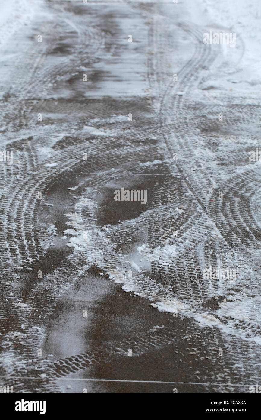 Snowy tracce di pneumatici su cemento. Foto Stock