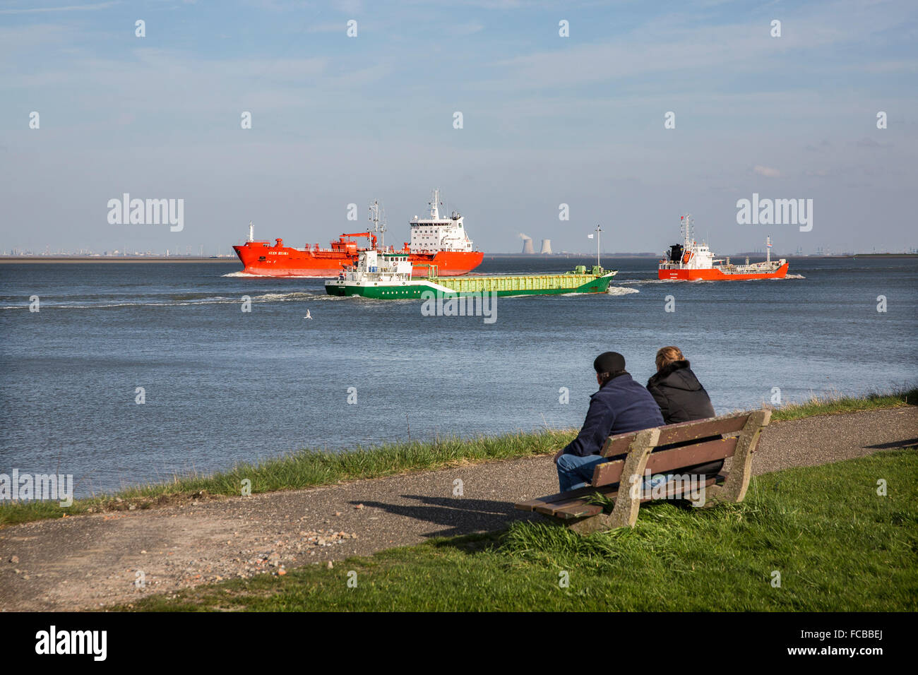 Paesi Bassi, Walsoorden, fiume Westerschelde. Giovane guardando le navi da carico Foto Stock