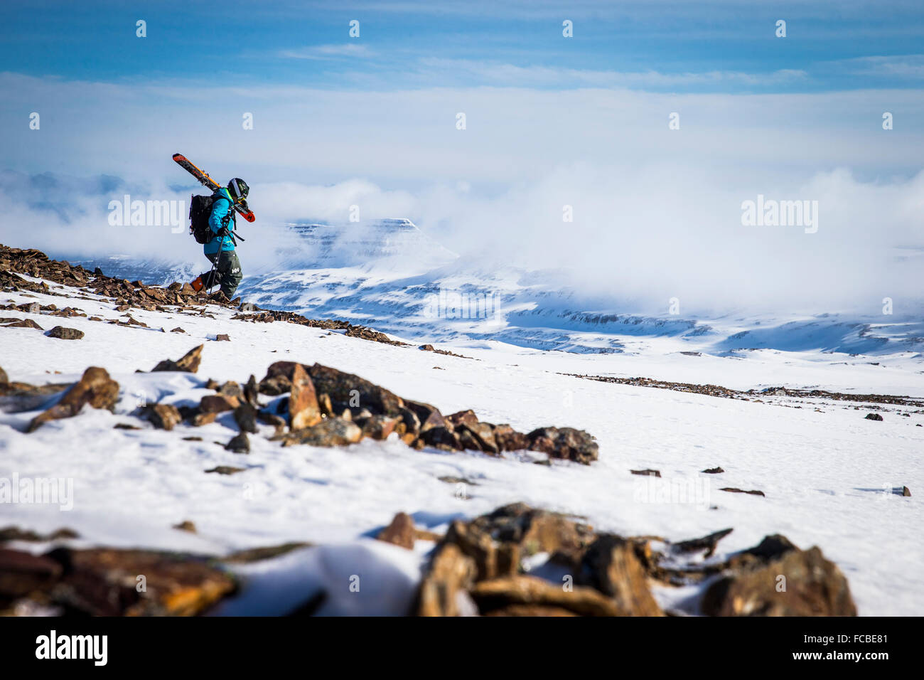 Un uomo a piedi lungo una cresta rocciosa mentre esplorare intorno Hornstrandir, Islanda Foto Stock