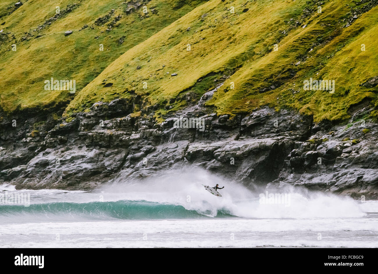 Surfista canadese, Noah Cohen, naviga le fredde acque delle isole Faerøer Foto Stock