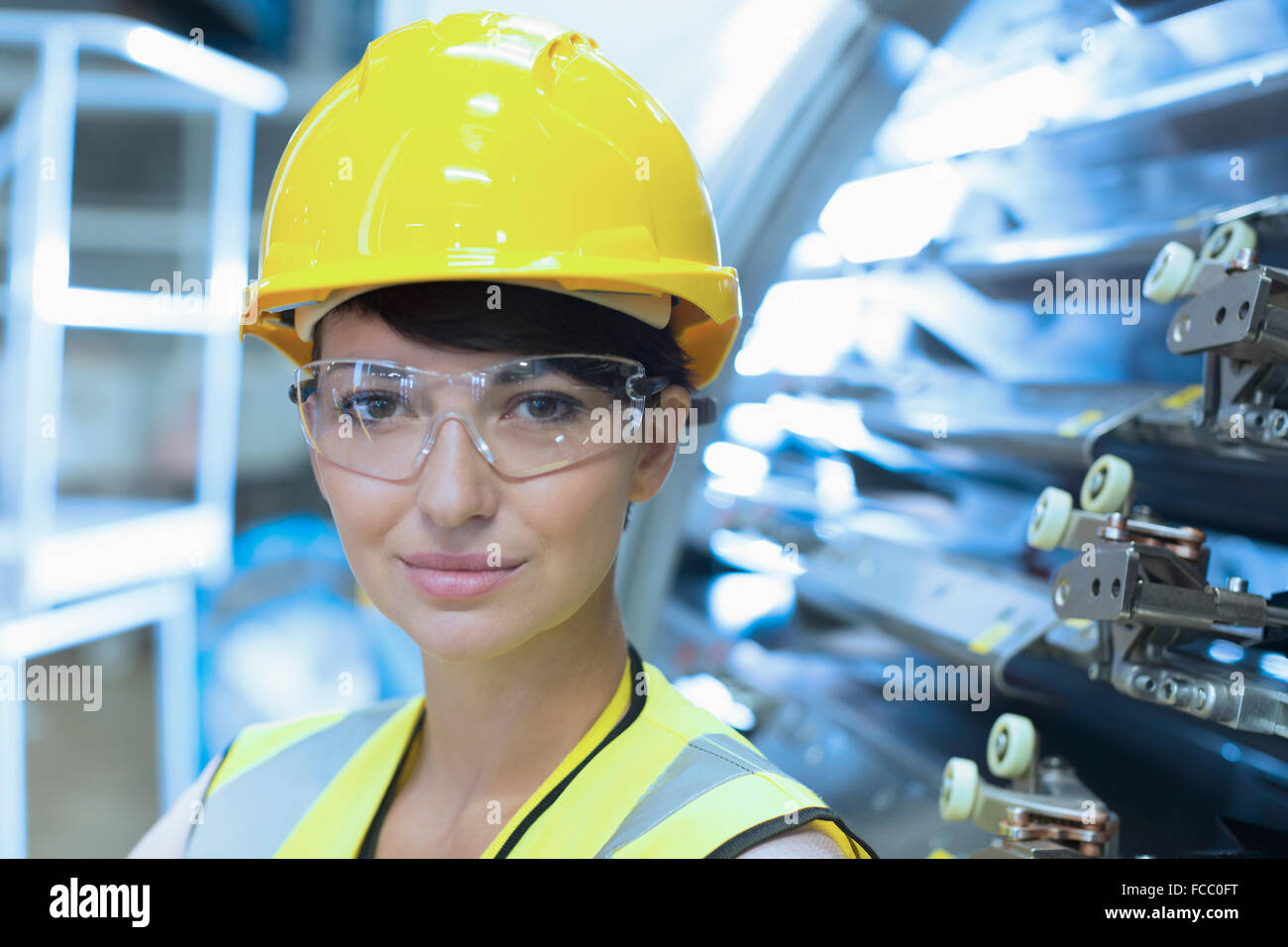 Close up ritratto femminile lavoratore fiducioso in hard-cappello e occhiali protettivi Foto Stock