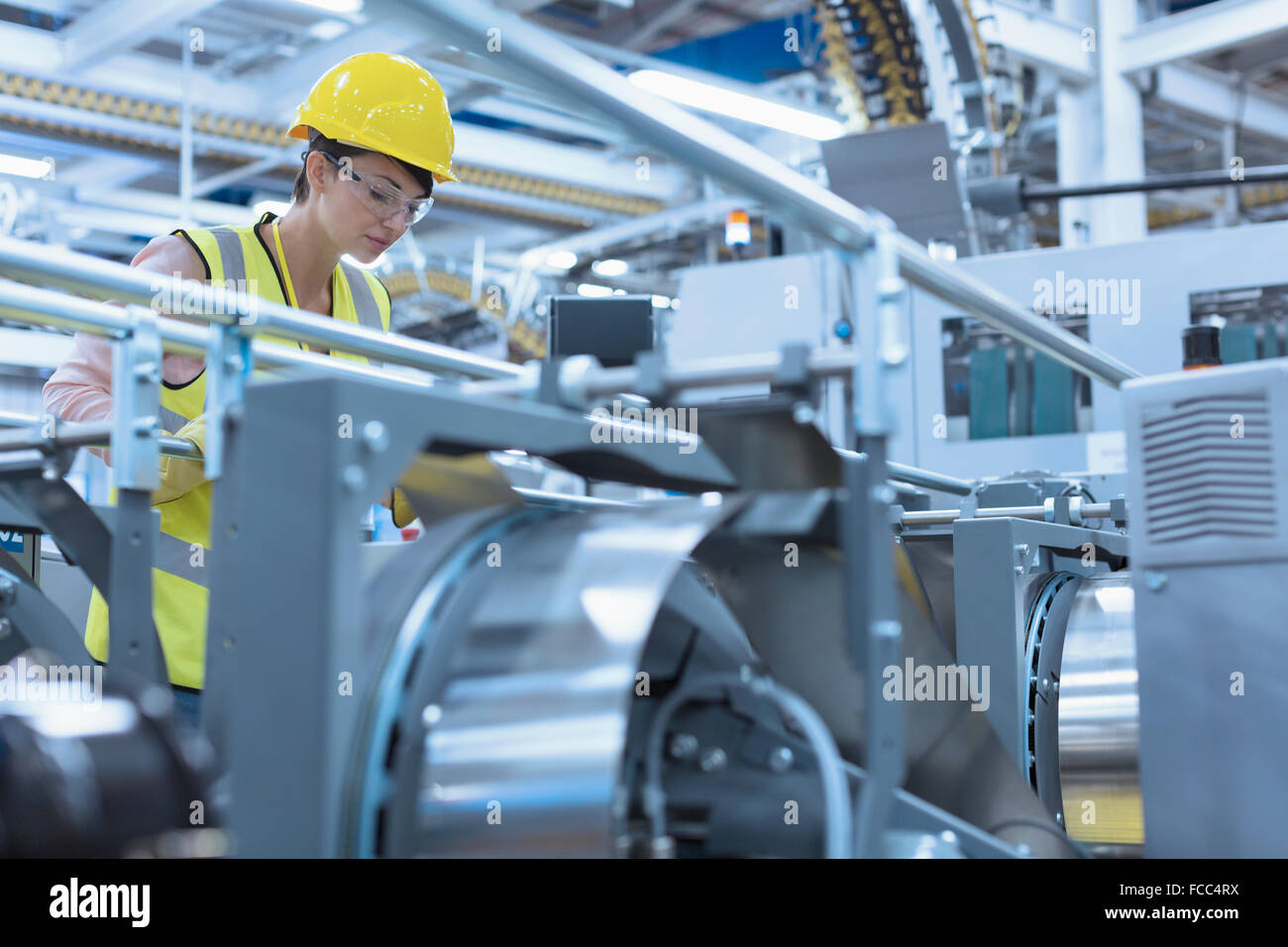 Lavoratore a macchinari in fabbrica Foto Stock