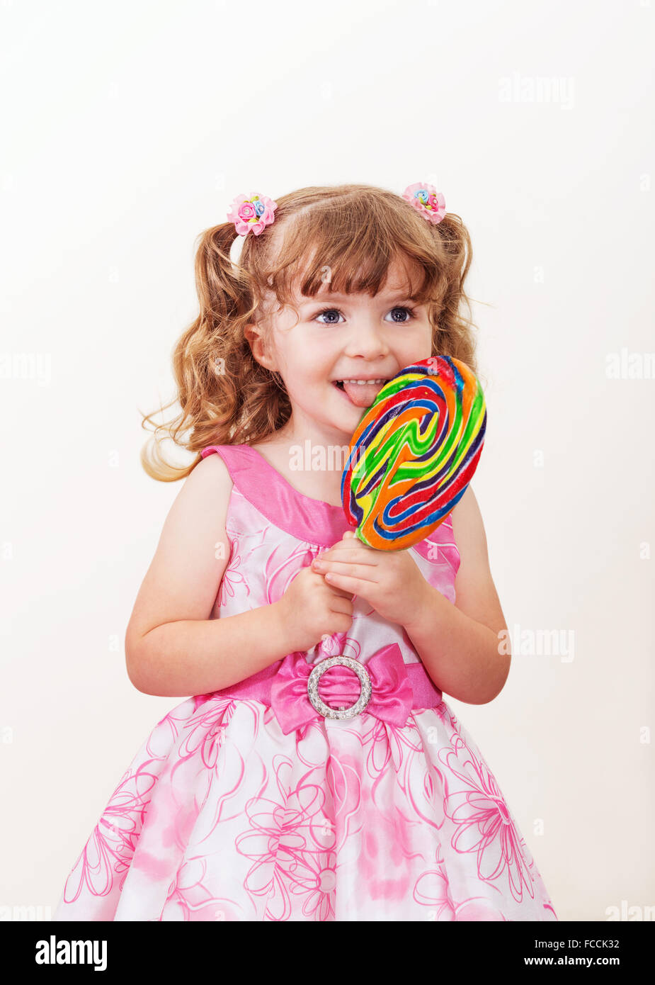 Ritratto di carino bambina con grande lecca-lecca colorati su uno sfondo luminoso Foto Stock