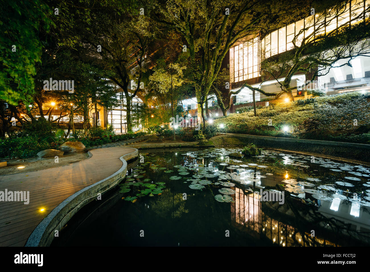 Piccolo laghetto e moderni edifici di notte, dall'Università di Hong Kong, a Hong Kong, Hong Kong. Foto Stock