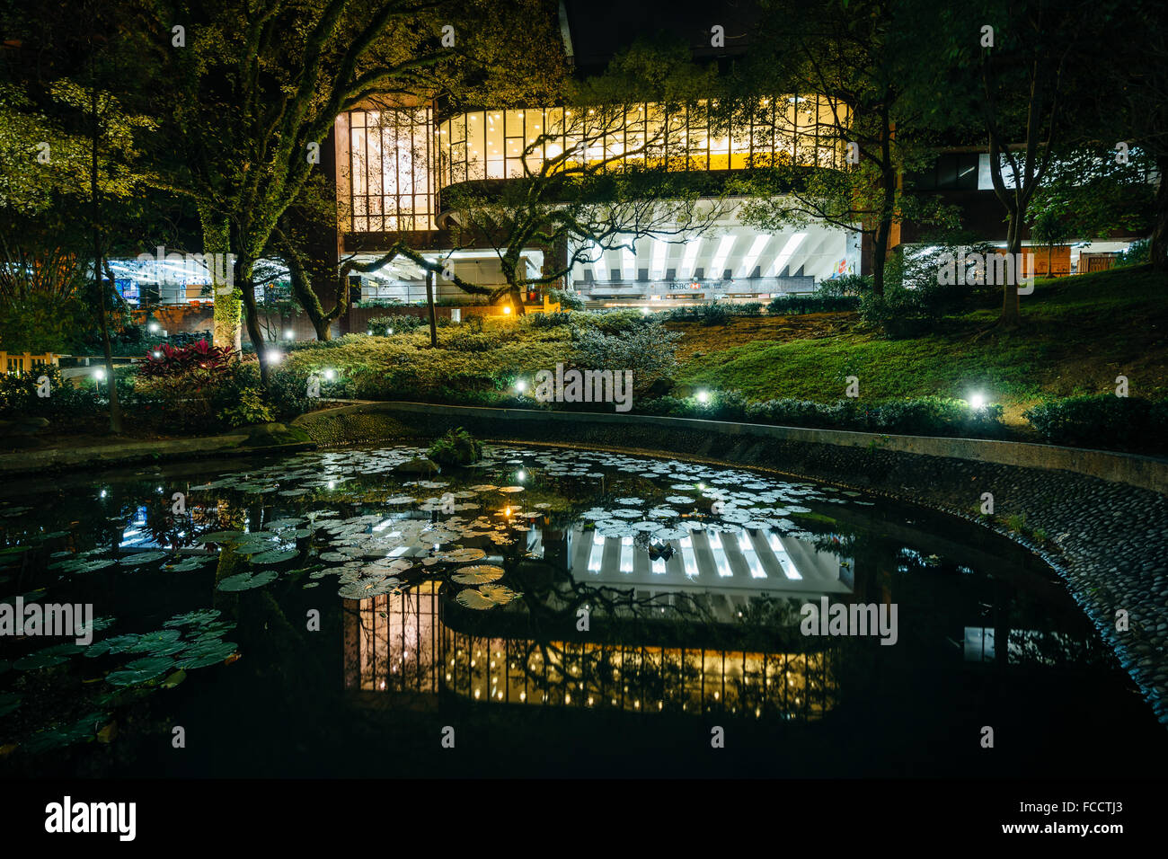 Piccolo laghetto e moderni edifici di notte, dall'Università di Hong Kong, a Hong Kong, Hong Kong. Foto Stock