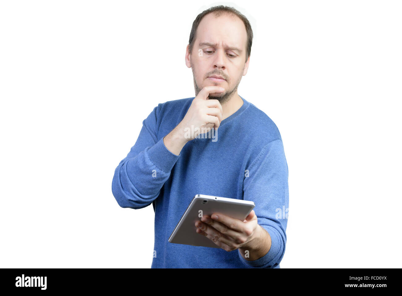 Giovane uomo maglietta blu holding tablet pensando Foto Stock