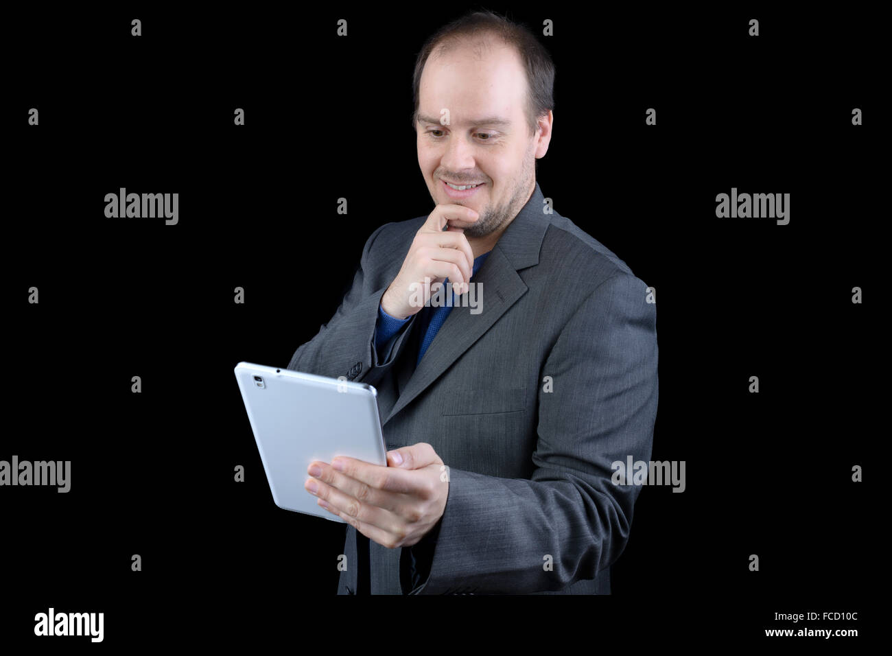 Giovane uomo grigio scuro tuta azienda sorridente tablet Foto Stock
