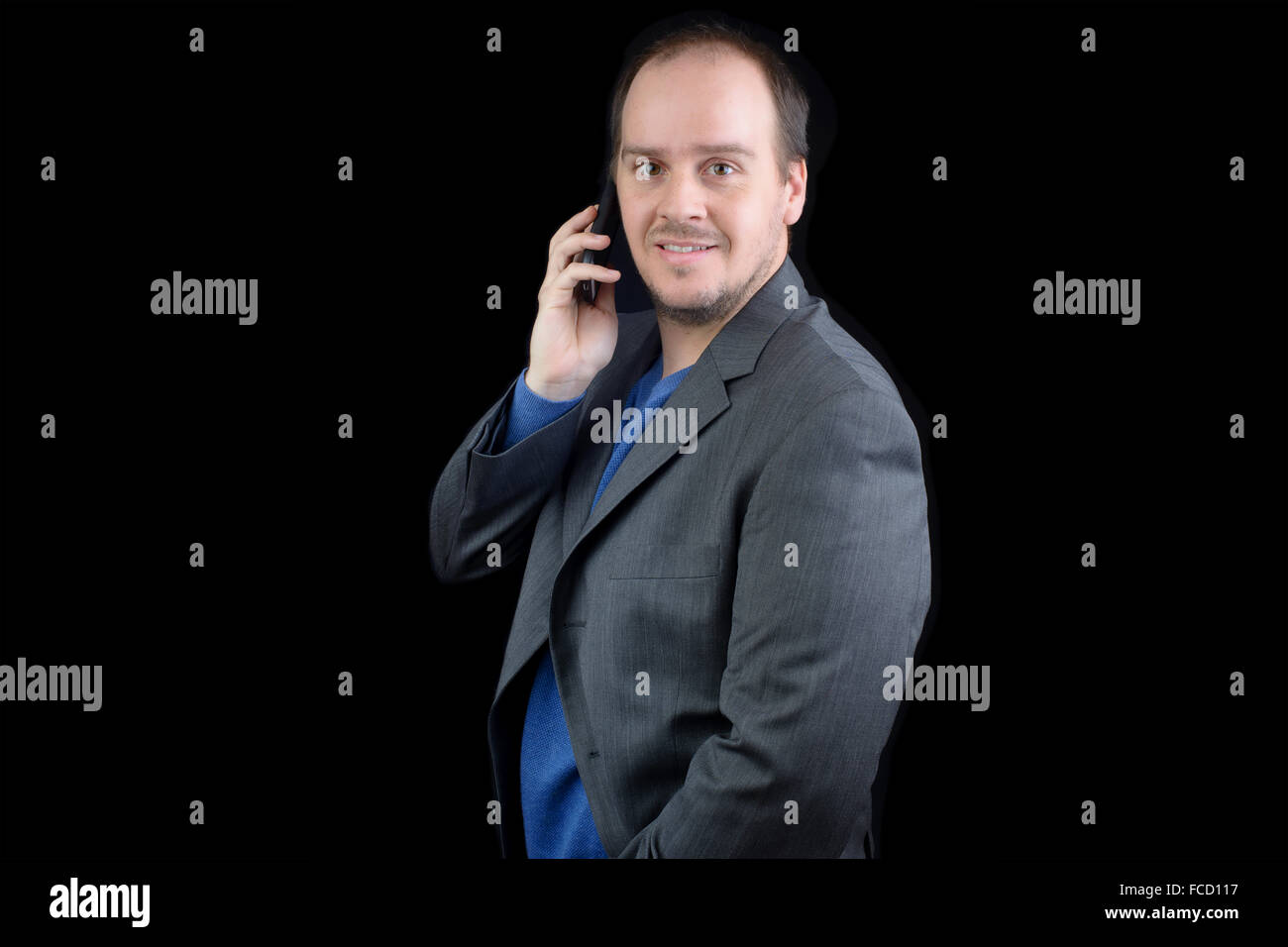 Giovane uomo grigio scuro suit parlando telefono cellulare sorridente Foto Stock