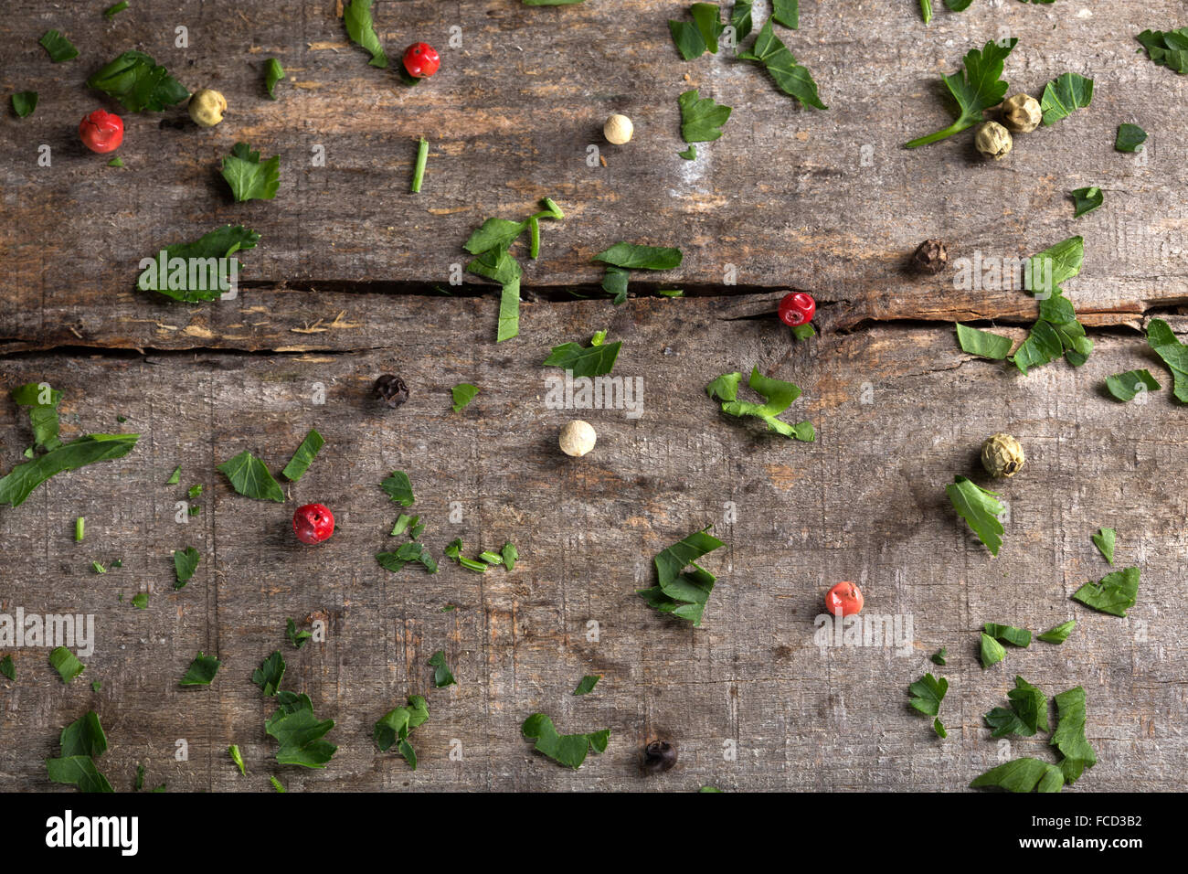 Sfondo di erbe - prezzemolo e pepe colorato su uno sfondo di legno, vista dall'alto Foto Stock
