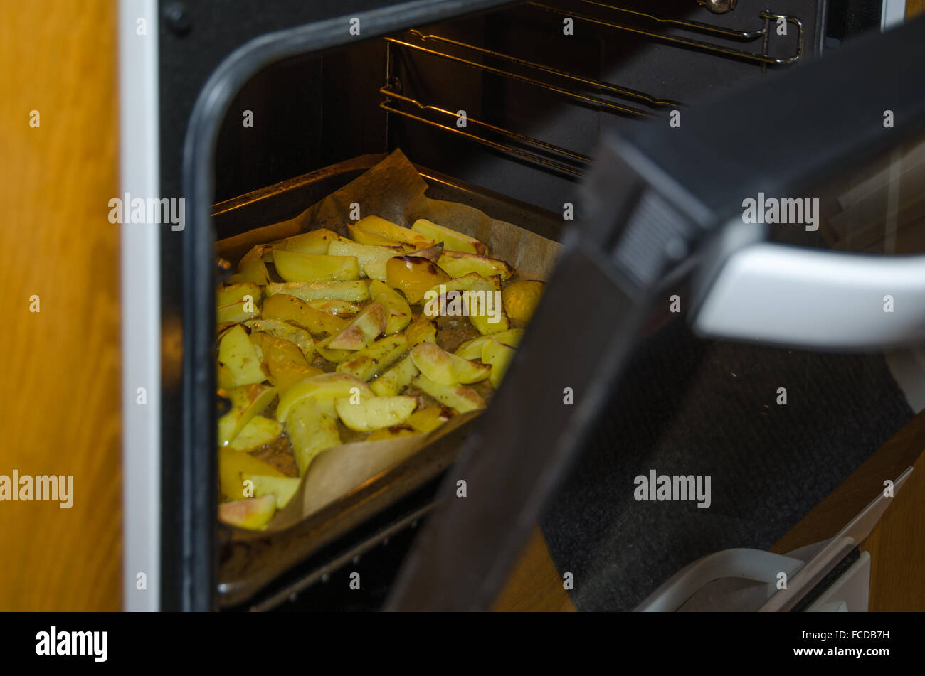 Sguardo al forno con fette di patate arrosto Foto Stock