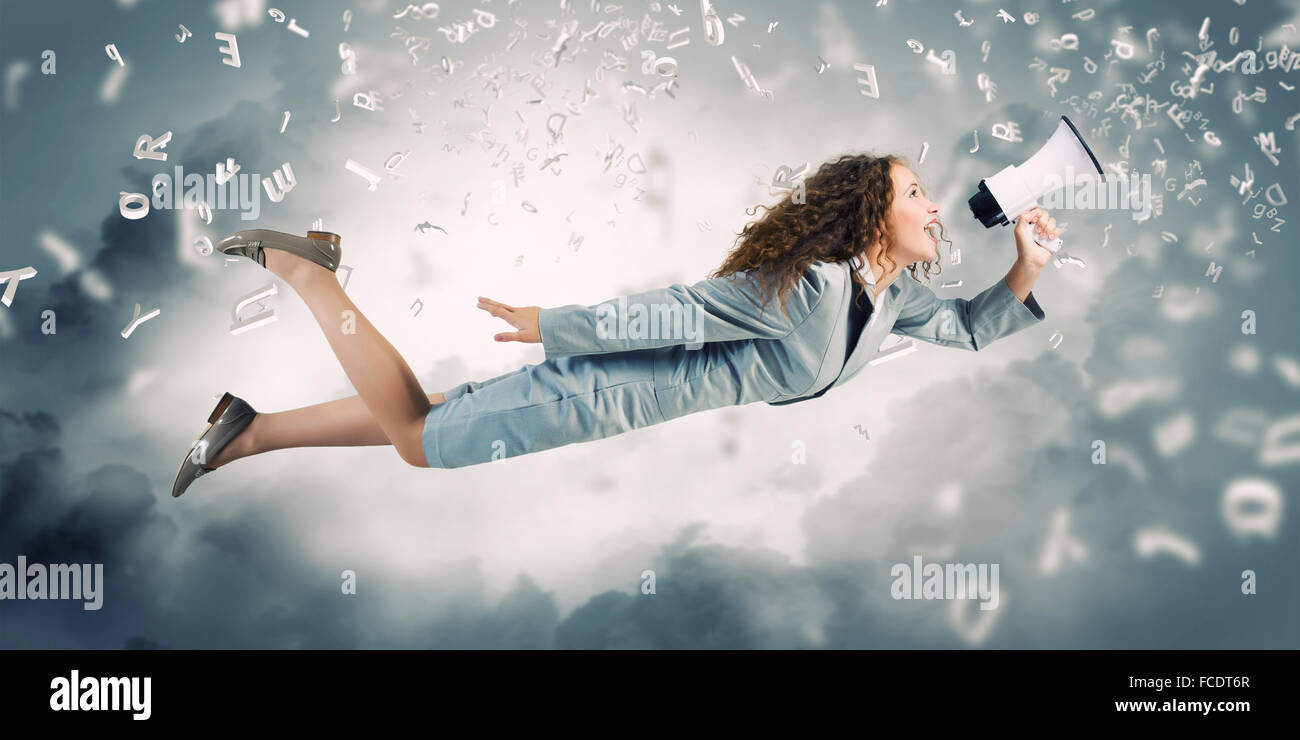 Giovane imprenditrice con megafono volare alto nel cielo Foto Stock