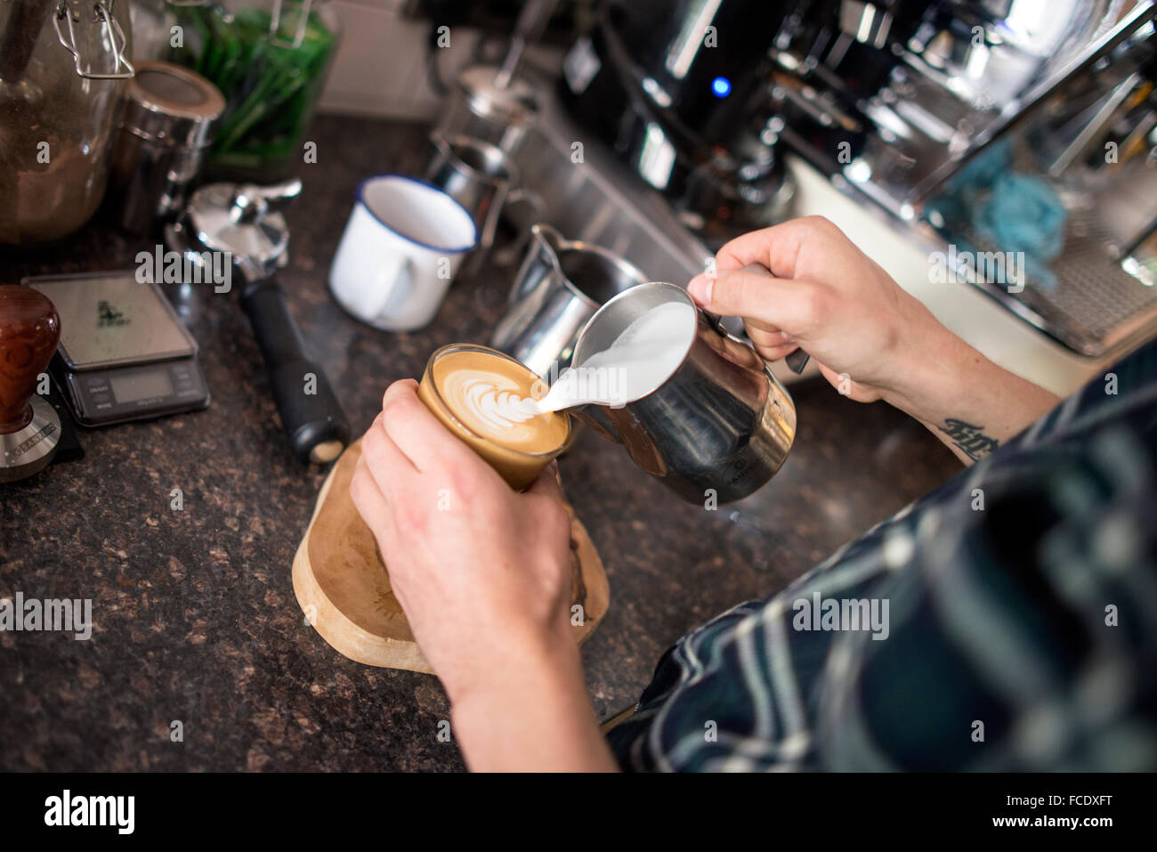 Barista rendendo il Perfetto piatto bianco Foto Stock