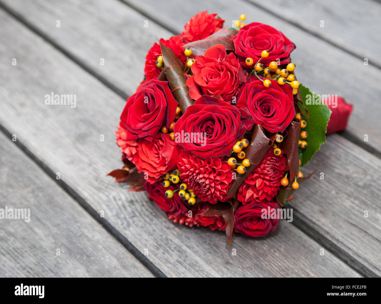 Red bridal bouquet di rose su sfondo di legno Foto Stock