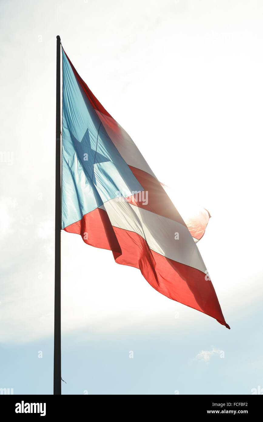 Puertorican bandiera sventola contro il cielo luminoso. Arroyo, Puerto Rico. Isola dei caraibi. USA il territorio. Foto Stock