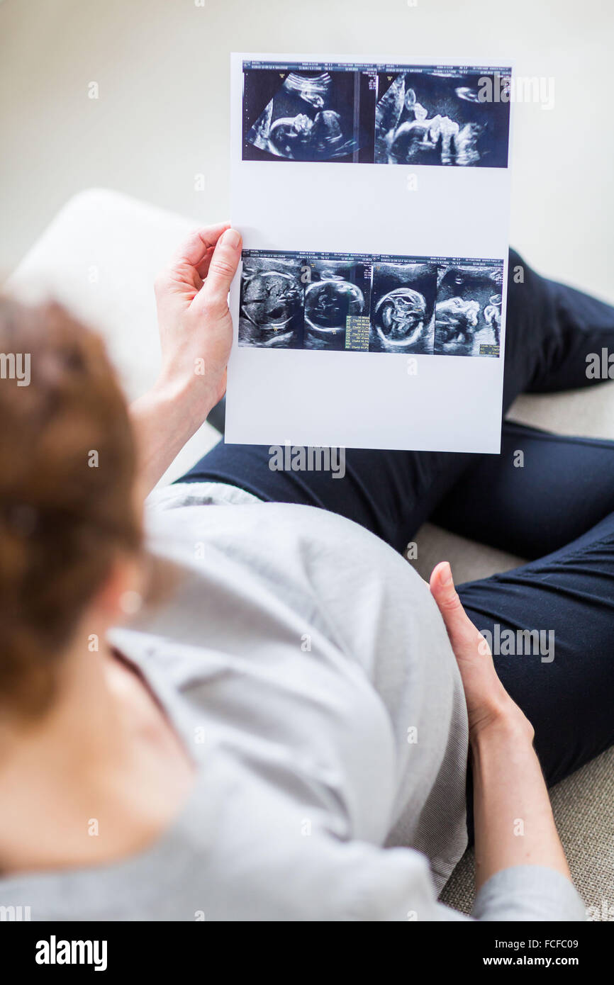 Donna che guarda la baby scan. Foto Stock