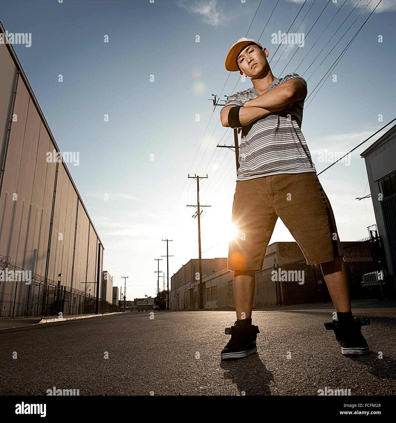 Un giovane uomo, un breakdancer in piedi su una strada con le braccia incrociate. Foto Stock