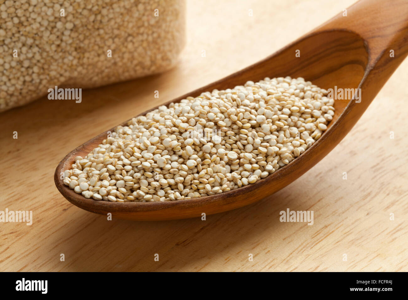 Materie di Quinoa semi su un cucchiaio di legno Foto Stock