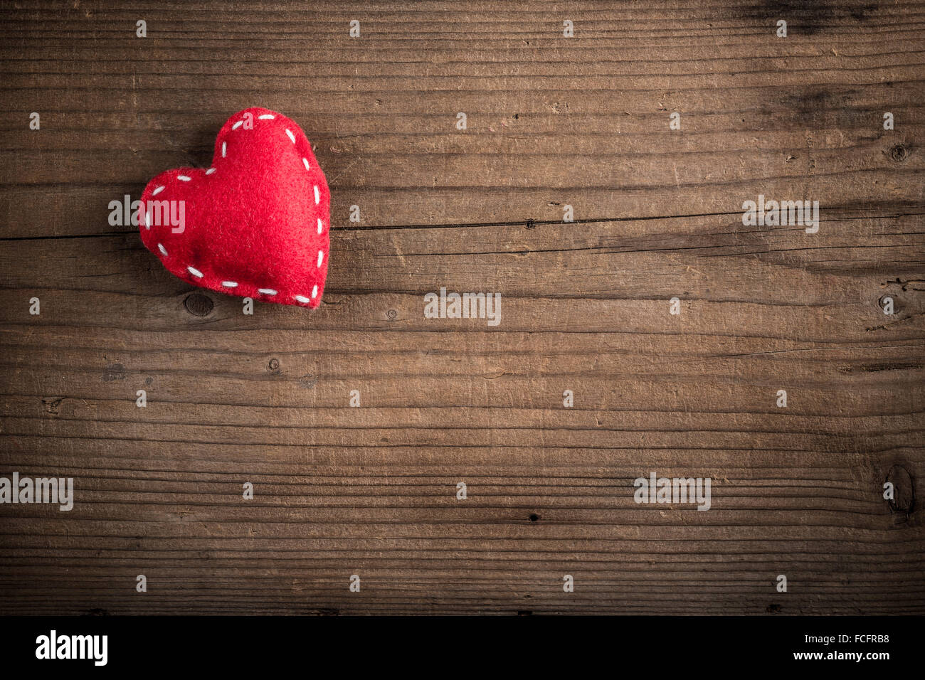 Feltro rosso cuore sul vecchio sfondo di legno Foto Stock