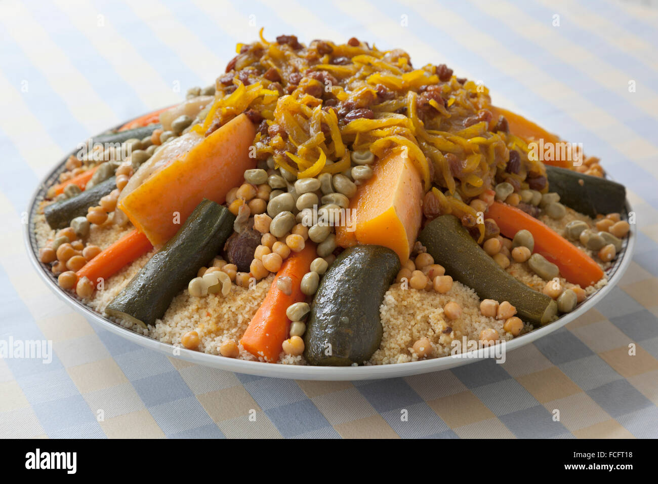 Tradizionale festa di couscous marocchino con cipolle e uva passa su un piatto di portata Foto Stock