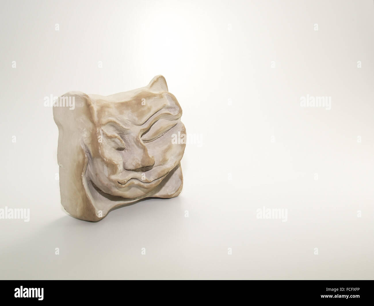 Scultura in argilla di angry sleeping scrunched up faccia su sfondo bianco. Scolpito da me, anche il fotografo, Zeljka Burazi Foto Stock